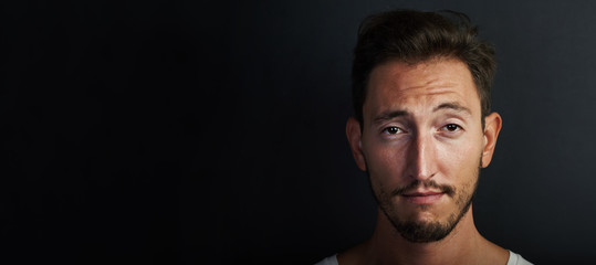 Portrait of cute young man wearing white tshirt and playing on the camera. Wide
