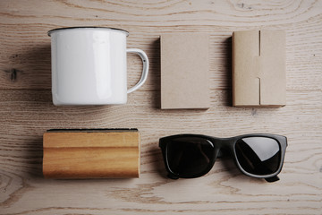 Top view of a office elements, sunglasses, cup on the wooden background . Horizontal