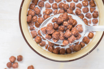 Spoon with chocolate balls and milk