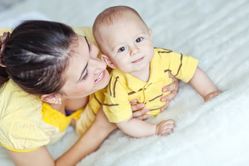 Happy mother with her baby in the morning bed