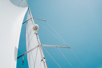 Big white sail of a sailing boat against the sky. Horizontal