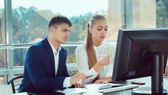 Success in business. Affiliates man and a woman reading good news on a computer screen, roughly rejoice, clap, laugh, hug
