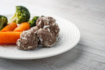 Meatballs with broccoli and carrots on the ceramic plate