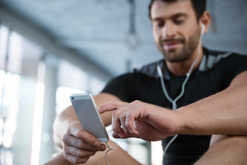 Fitness man using smartphone in gym