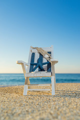 tropical beach with a sun-lounger facing the blue sea