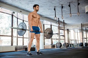 Fototapeta premium Muscular man workout with barbell