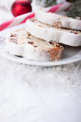 German dresdner stollen cake slices on a white background with false snow.