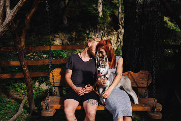 Obraz na płótnie Canvas beautiful couple together with dog on a swing