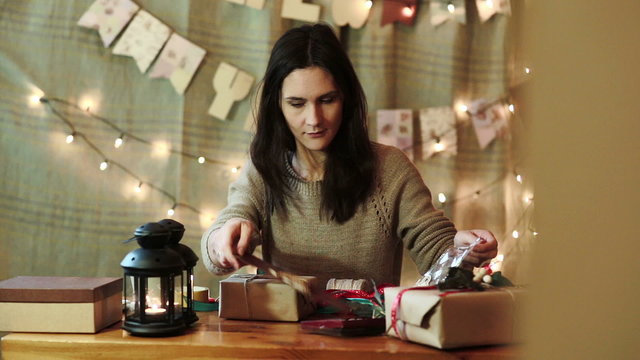 Young Woman Wrapping Christmas Gifts At Home