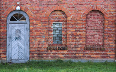 Arches and door in a wall made from red bricks