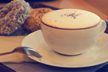 hot choccolate with donuts on warm color tone style background, soft and blur concept