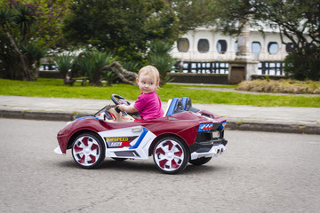 Baby girl riding on small car