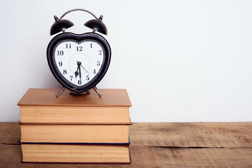books and alarm clock on wooden background. Education equipment, education concept