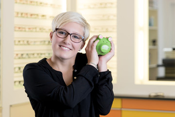 Kundin beim Optiker mit Sparschwein