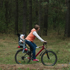 Obraz premium mother and daughter riding bike in the forest