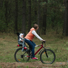 mother and daughter riding bike in the forest