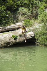 Little girl jumping in a river