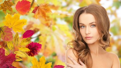 Fototapeta premium beautiful young woman face over autumn leaves