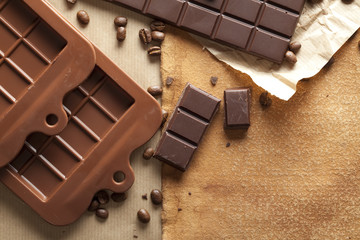 Dark chocolate and coffee beans on old paper background