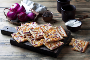 Tart flambee with purple onions, bacon and apples (Flammkuchen), selective focus