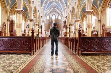 man standing praying in church