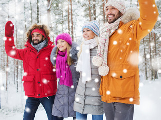 group of friends waving hands in winter forest