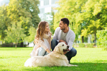 happy couple with labrador dog walking in city