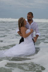 Fototapeta na wymiar An attractive bride and groom getting married by the beach