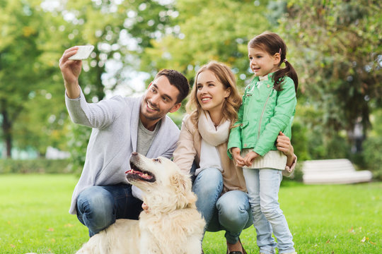 happy family with dog taking selfie by smartphone