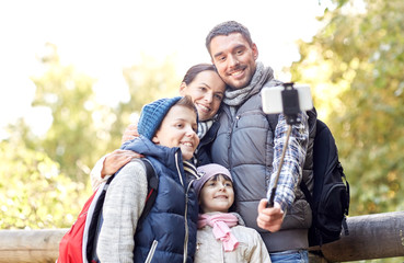 Naklejka na ściany i meble happy family with smartphone selfie stick in woods