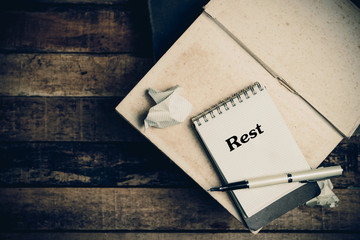 Rest word book on wood table vertical