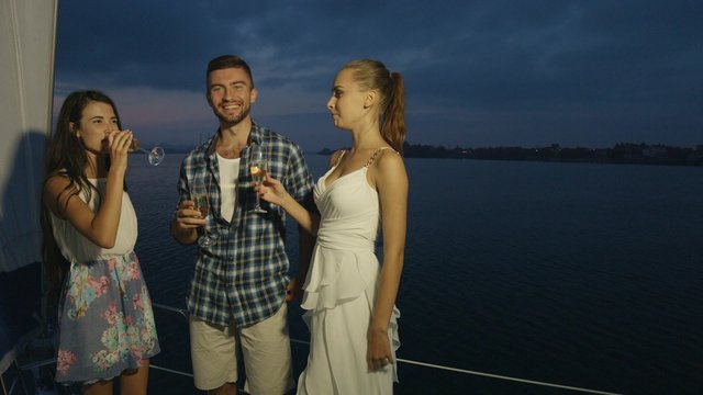 Guy and  girl drinking champagne on the yacht.