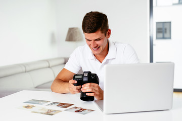 Photographer. Young photographer browsing his pictures on DSLR Camera