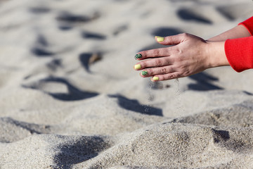 Close-up photo of the woman hands playing with sand
