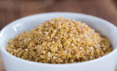 Raw Bulgur (on wooden background)