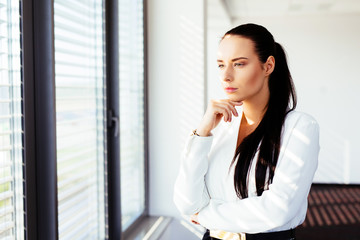 Pensive businesswoman looking from the window