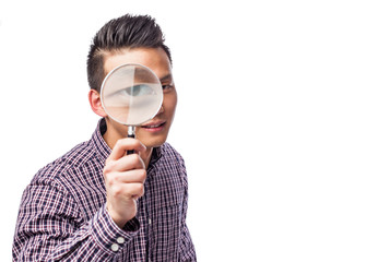 handsome young asian man looking through a magnifying glass