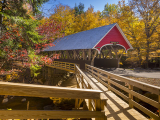 Red covered bridge in Fanconia New Hampshire during Fall season - obrazy, fototapety, plakaty