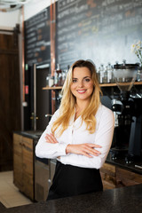 Small business owner. Pretty barista smiling at coffee shop
