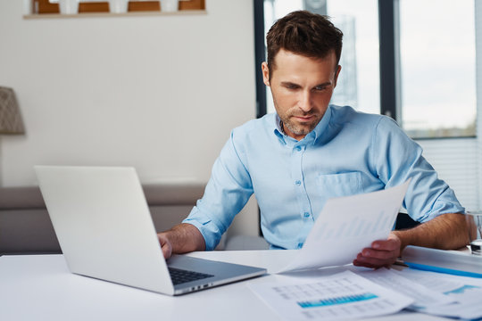 Young man working with laptop at home