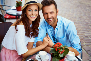 Happy couple enjoying sitting in outdoor cafe