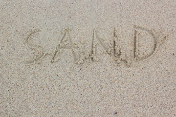 Alphabet letters "sand" handwritten on sand