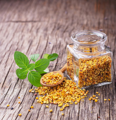 Bee pollen granules and propolis in wooden scoop