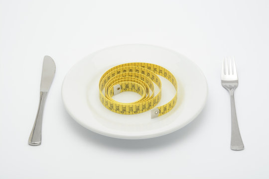 Plato con cinta m&eacute;trica de sastre, tenedor y cuchillo