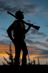 silhouette of cowboy with shotgun over shoulder sunset