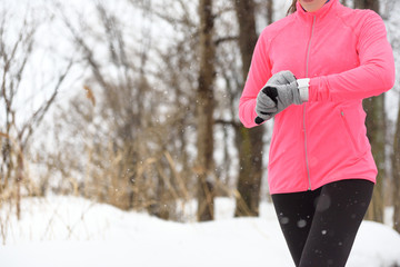 Runner using smartwatch jogging running in winter