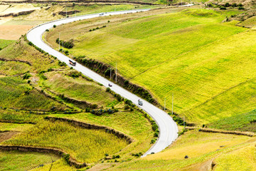 Experience the breathtaking journey on a high altitude road in Ecuador,traversing through lush agricultural landscapes and stunning scenic views.
