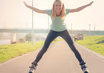 Young fitness woman roller skating outdoors. Beautiful happy girl enjoying.Fitness motivation,...