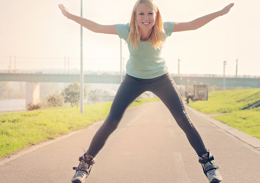Young fitness woman roller skating outdoors. Beautiful happy girl enjoying.Fitness motivation, sport, summer, rollerskating and healthy lifestyle concept