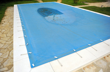 Protecting a swimming pool with a blue tarp in winter